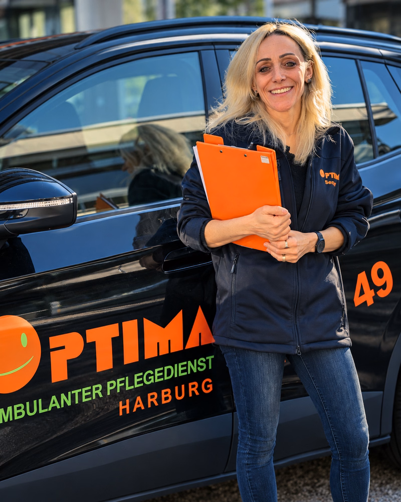 Senay Y. Polat, Pflegedienstleitung von OPTIMA, vor dem Dienstwagen in Harburg